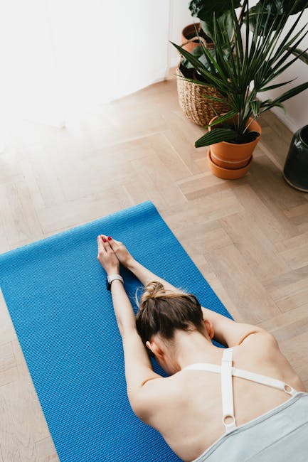Woman practicing yoga in a sunlit room with plants